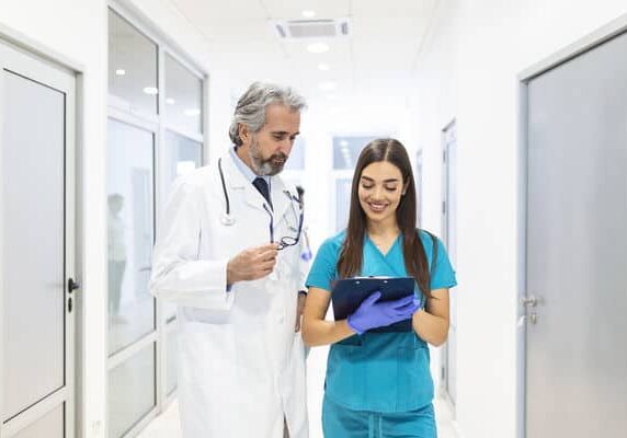 doctor with nurse looking at clipboard